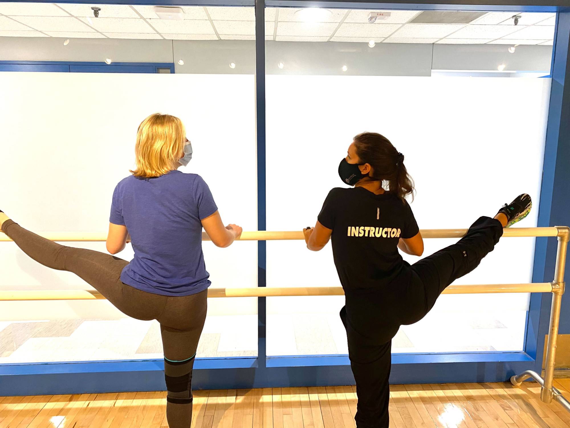 Instructor and student working together at the barre.